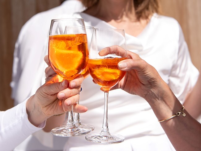 Personen, die auf der Terrasse Aperol und andere Getränke genießen